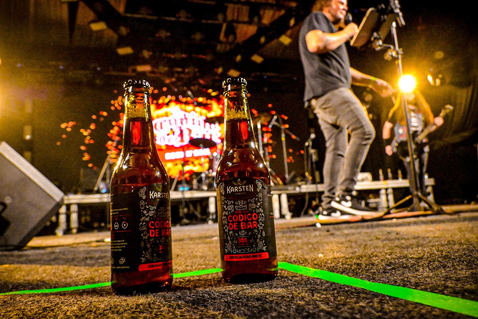 Duas garrafas da Red Ale Código de Bar na beira do palco durante o show
